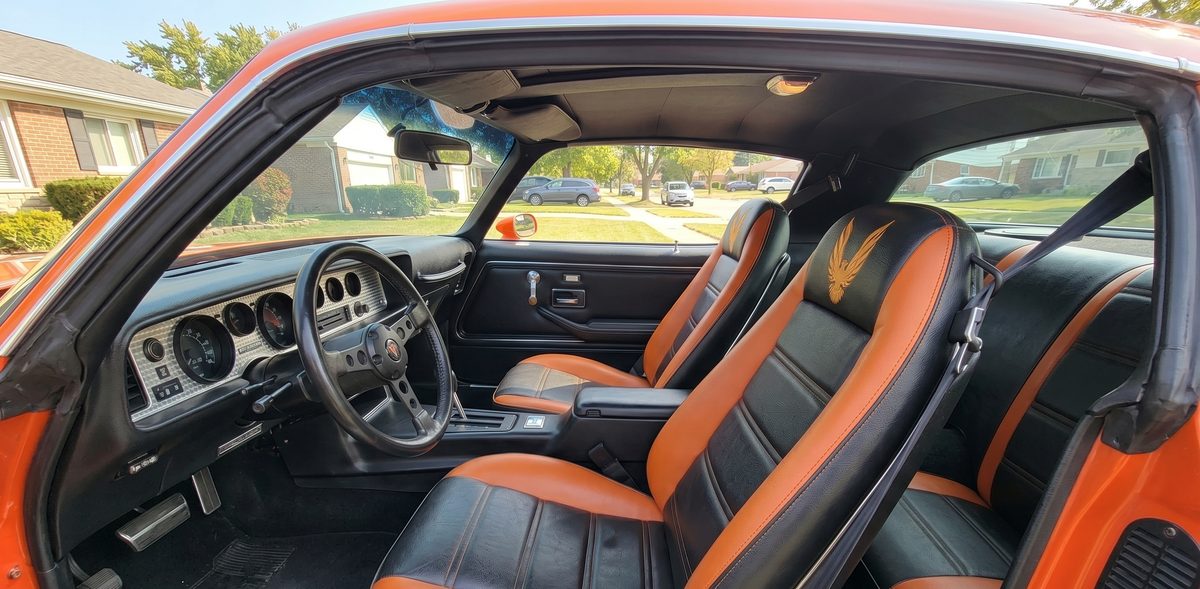 Orange and black custom leather seats installed in a Trans Am interior