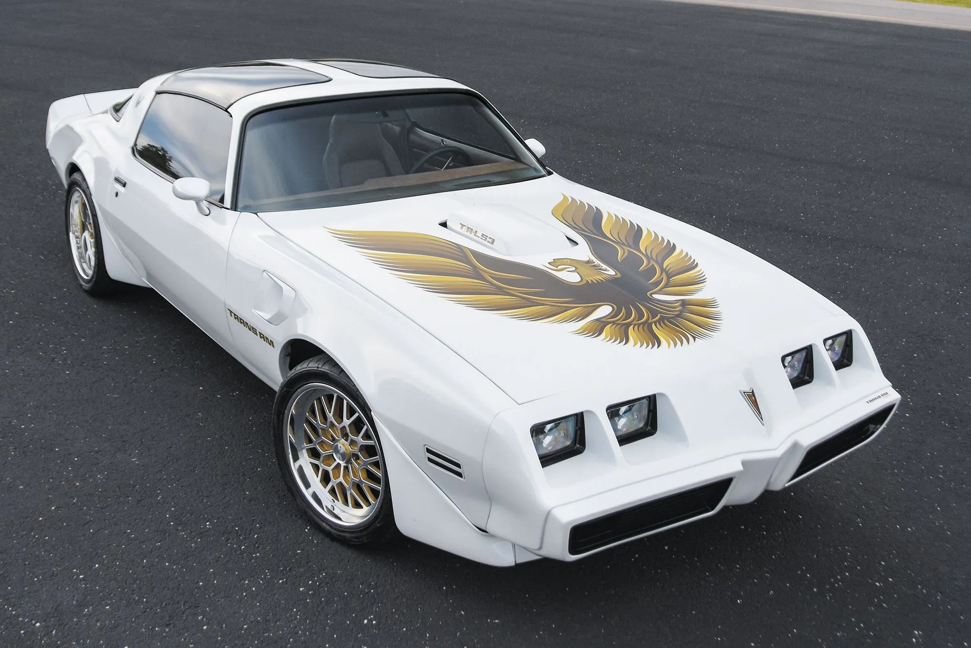 White 1979 Pontiac Trans Am with the gold hood bird decal, shaker scoop, and snowflake wheels